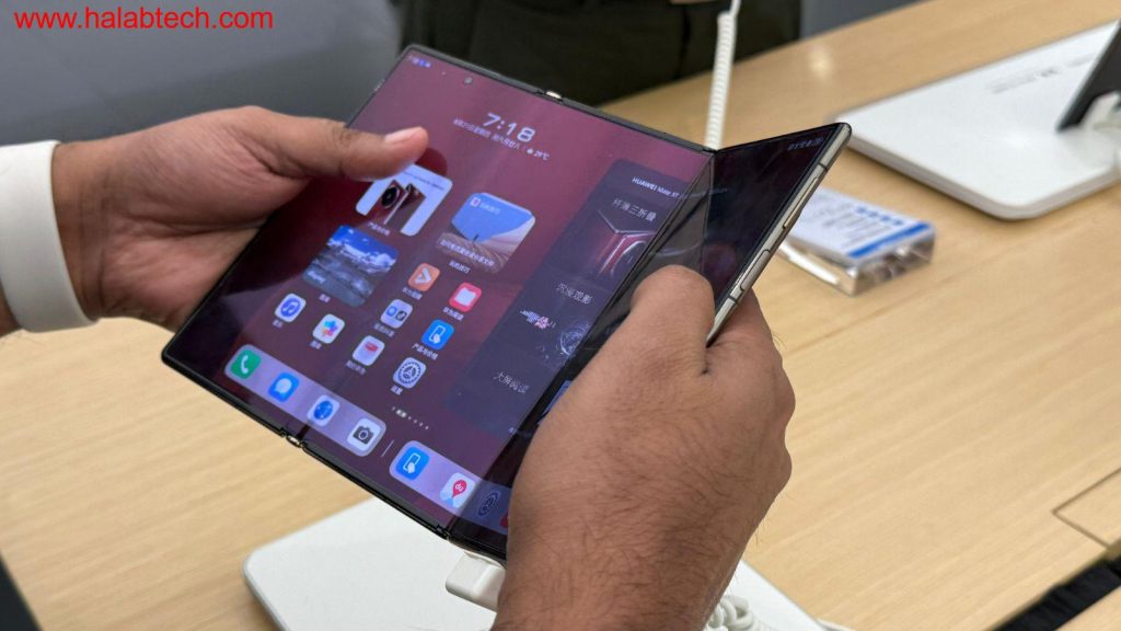 صورة للهاتف هواوي Mate XT ثلاثي الطي وهو مطوٍ جزئياً في متجر هواوي بشنتشن