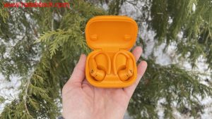سماعات Powerbeats Pro 2 مع شاشة iPhone تظهر تطبيق اللياقة البدنية.